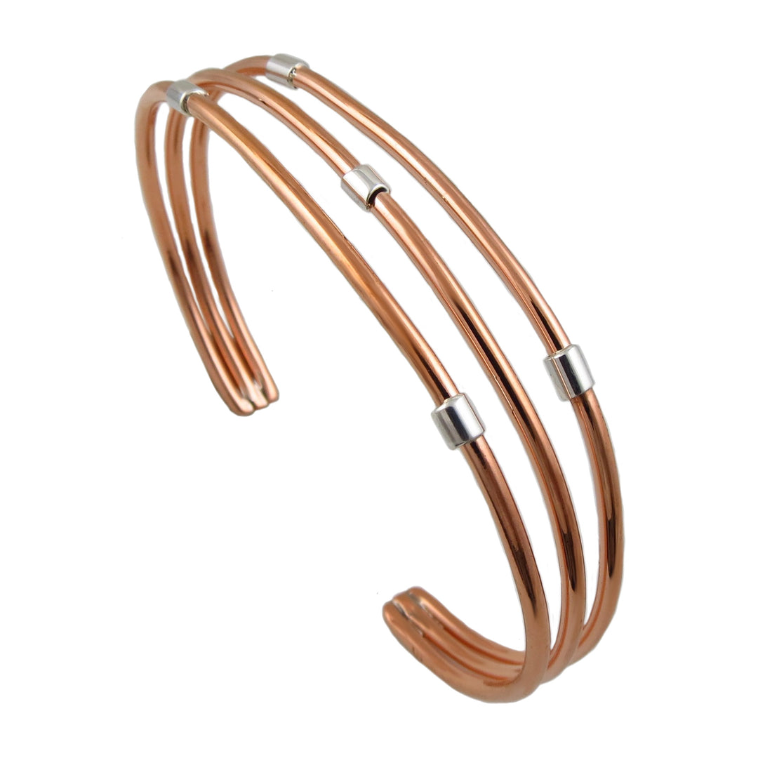 Copper bracelet featuring silver accents on a white background.