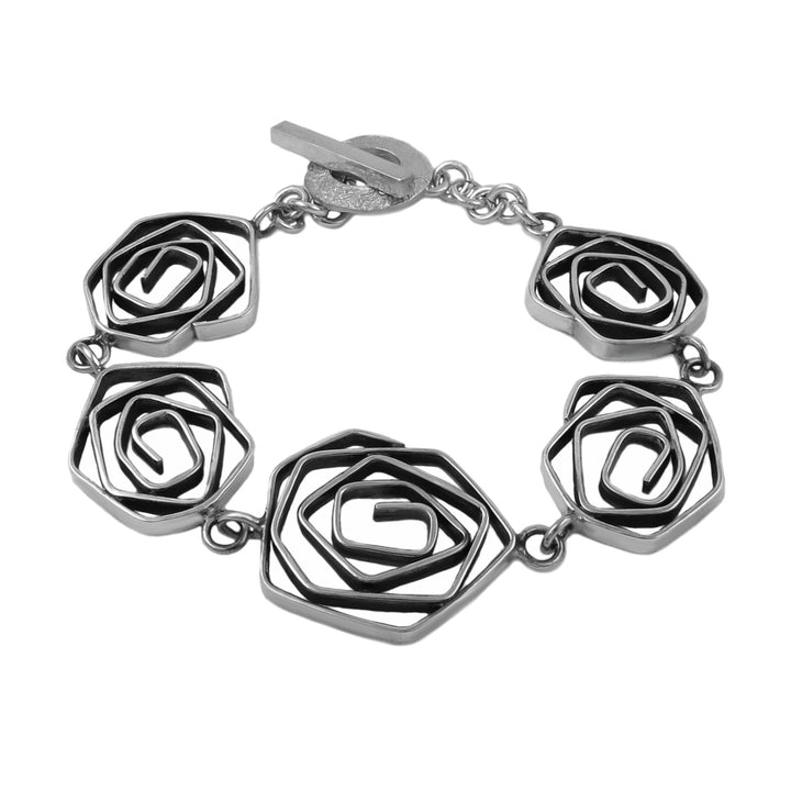 Sterling silver bracelet with spiral links on a white background.