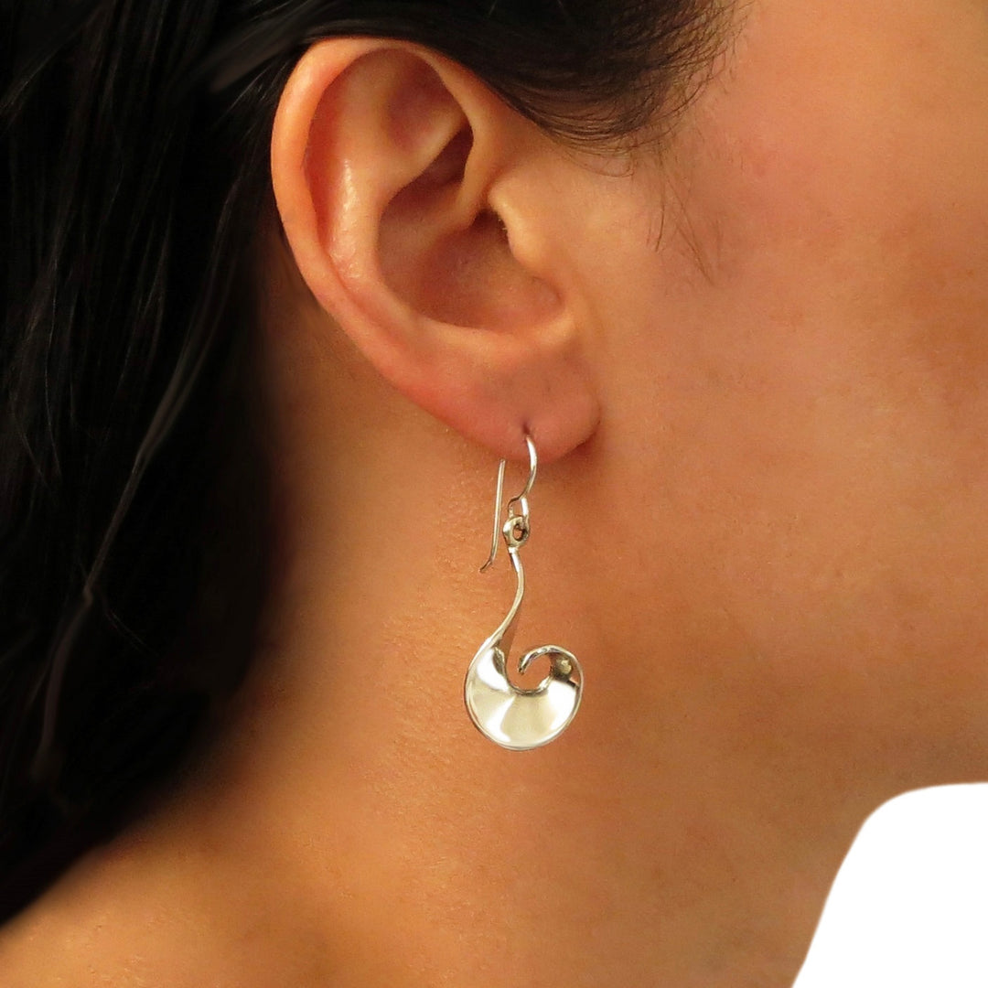 Spiral silver earrings worn by a woman with dark hair