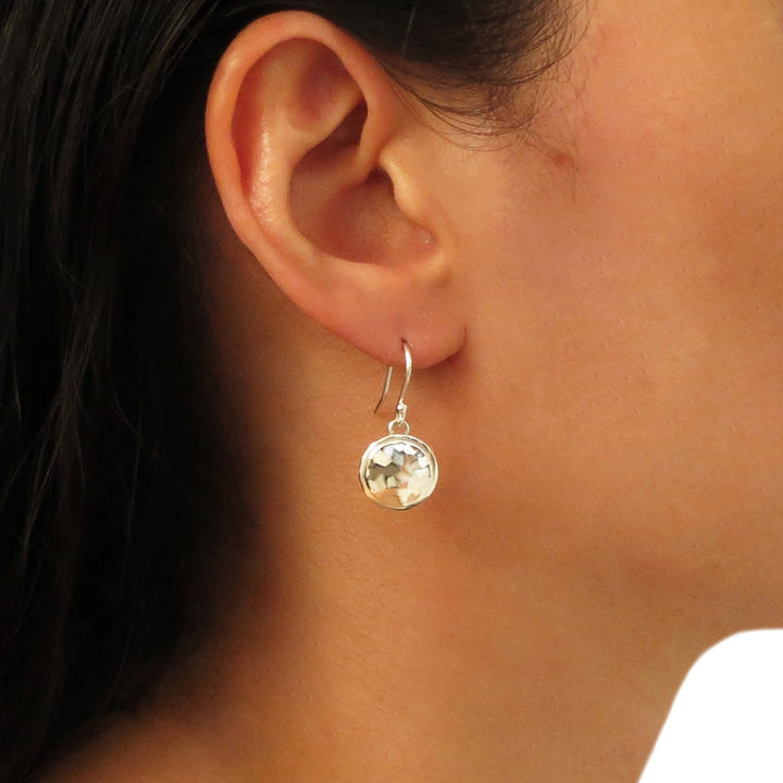 Hammered silver drop earrings worm by a woman with dark hair