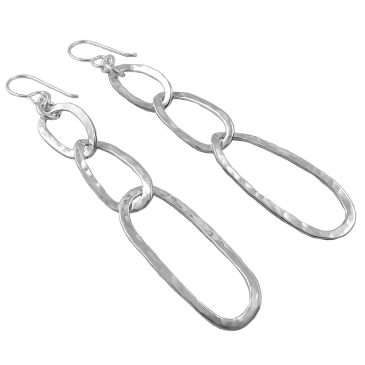 A pair of long silver curb chain earrings with a textured hand-hammered finish, hanging from secure ear hooks.