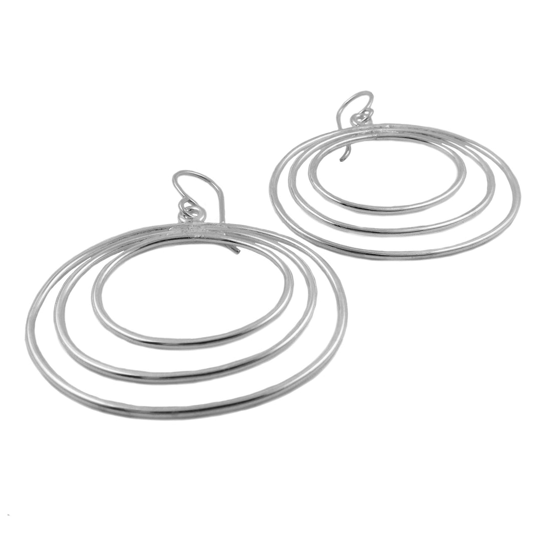 Ladies wide triple circle drop earrings in sterling silver on a white background.