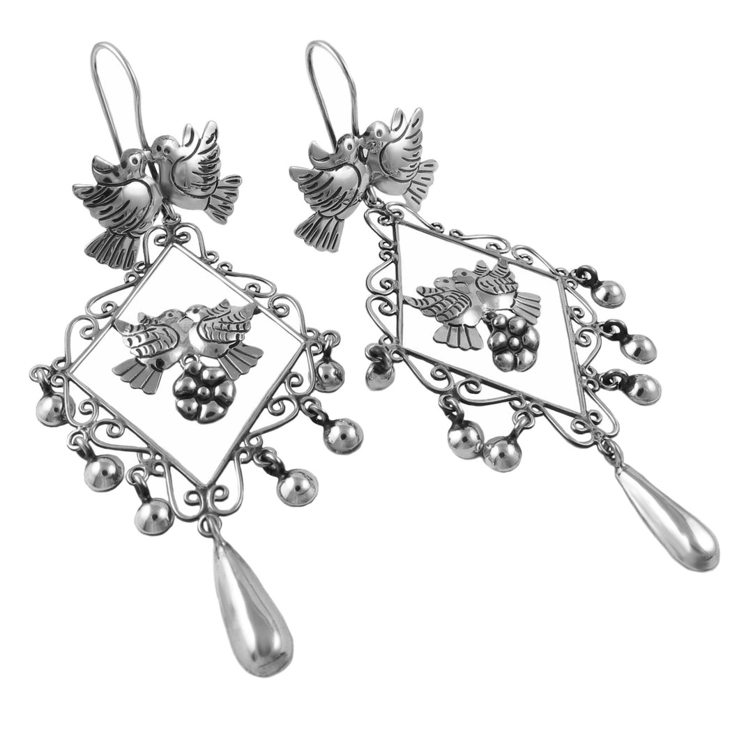 Long silver chandelier earrings on a white background