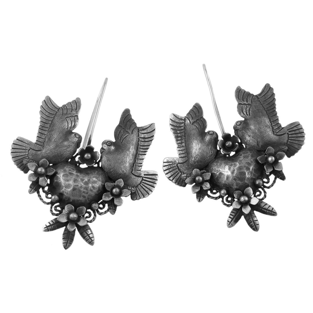 Taxco silver lovebird and flower earrings with an antiqued finish on a white background.