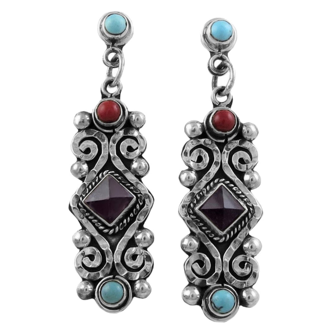 Pair of silver earrings with amethyst gemstones on a white background