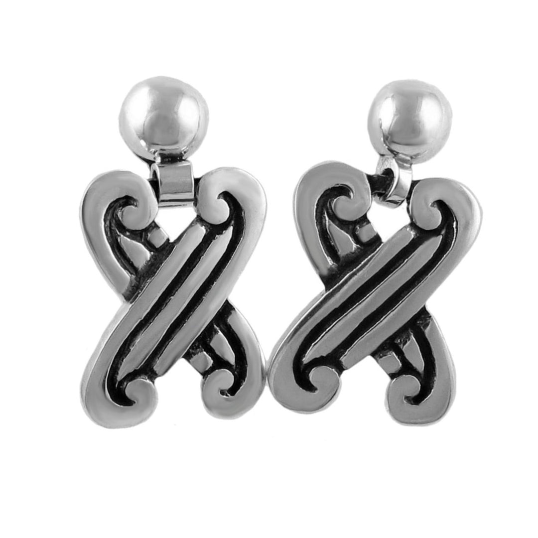 Pair of solid Taxco silver earrings with black designs on a white background