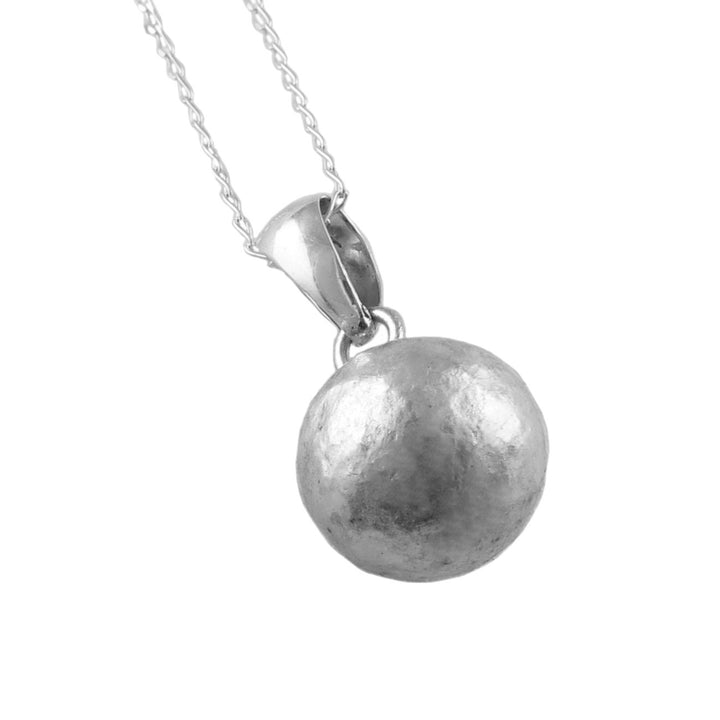 Silver ball bead pendant with a matt textured finish on a chain against a white background