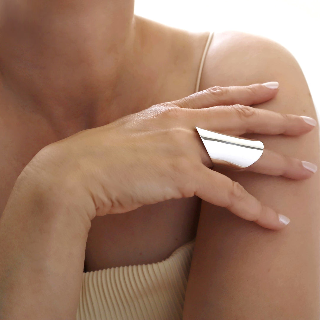 A half finger sterling silver ring worn by a woman with a yellow top