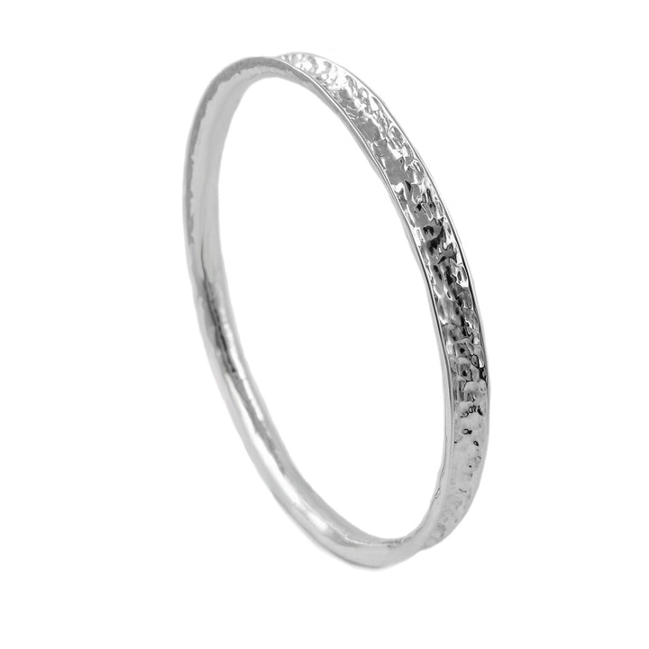 A textured hammered circle bracelet in sterling silver on a white background.