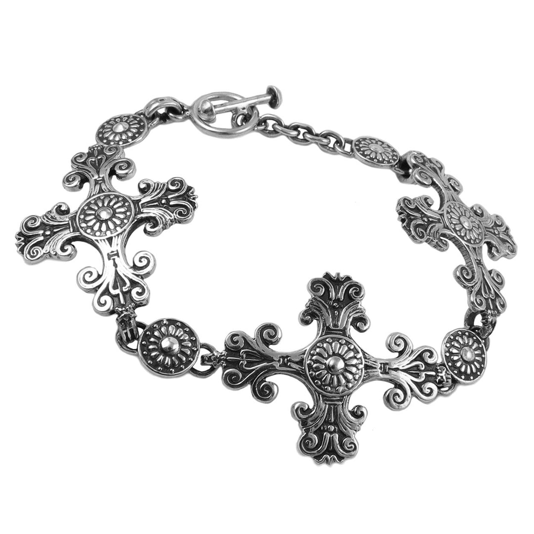 A Baroque religious cross ink sterling silver bracelet on a white background.
