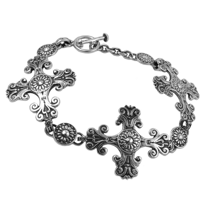 A Baroque religious cross ink sterling silver bracelet on a white background.