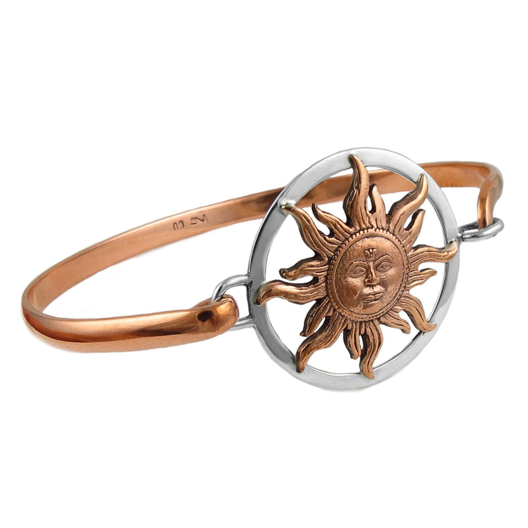 A bracelet featuring a sun motif, with a mix of copper and silver colors, a front hook fastener, and a British sterling silver hallmark.