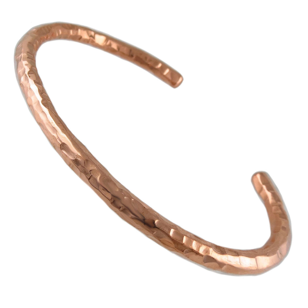 Copper bracelet cuff with a textured hand-hammered finish on a white background