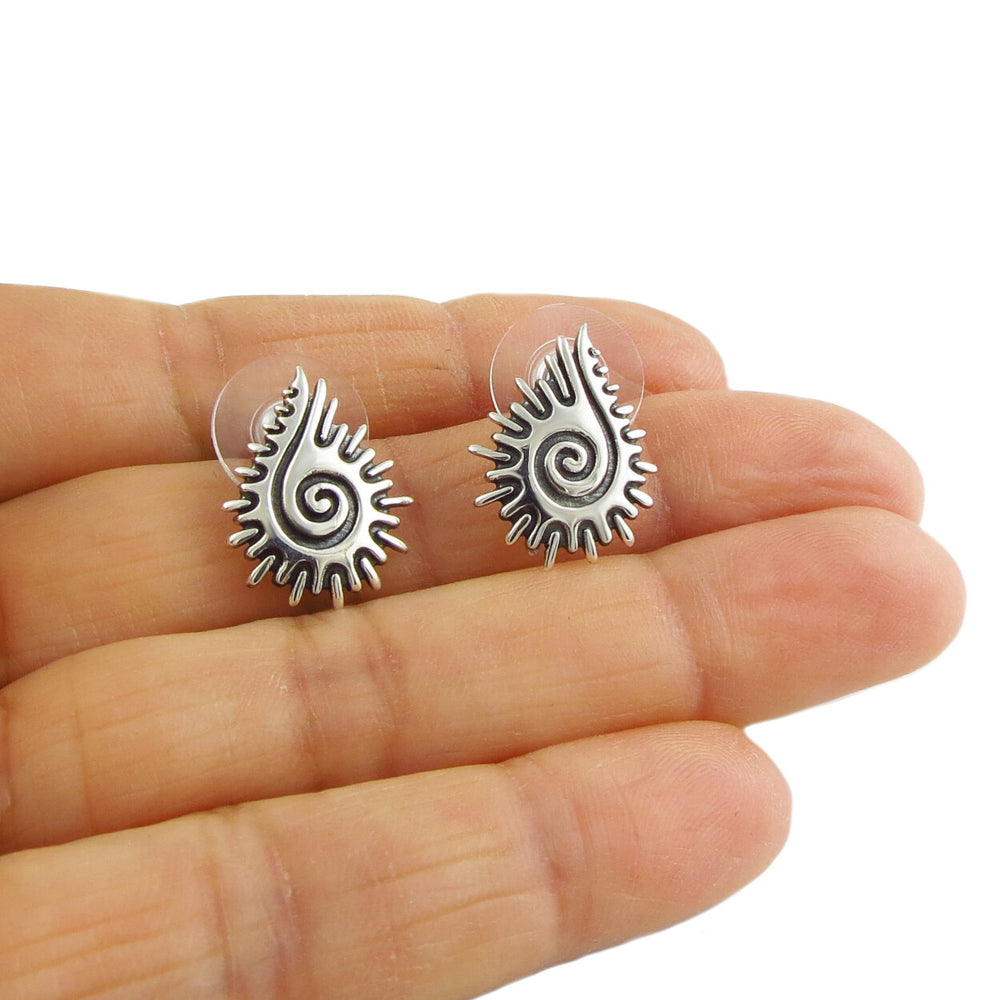 Maria Belen Nilson eashell stud earrings held in a perspon's hand.