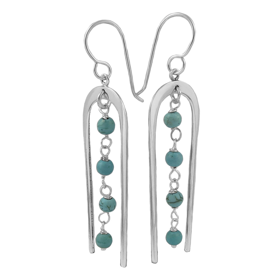 Silver earrings with blue beads on a white background