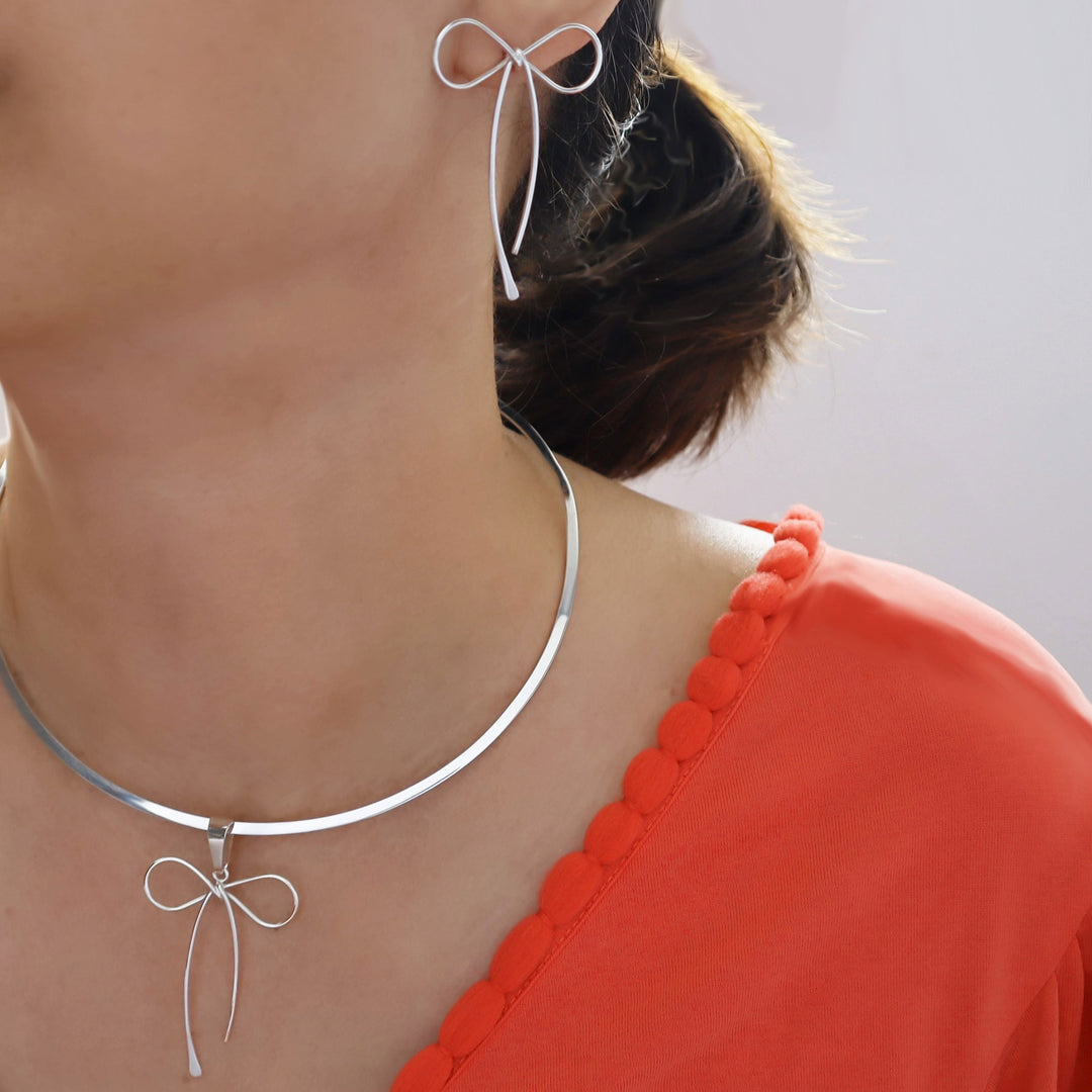 Long sterling silver bow earrings with curved ribbon drops