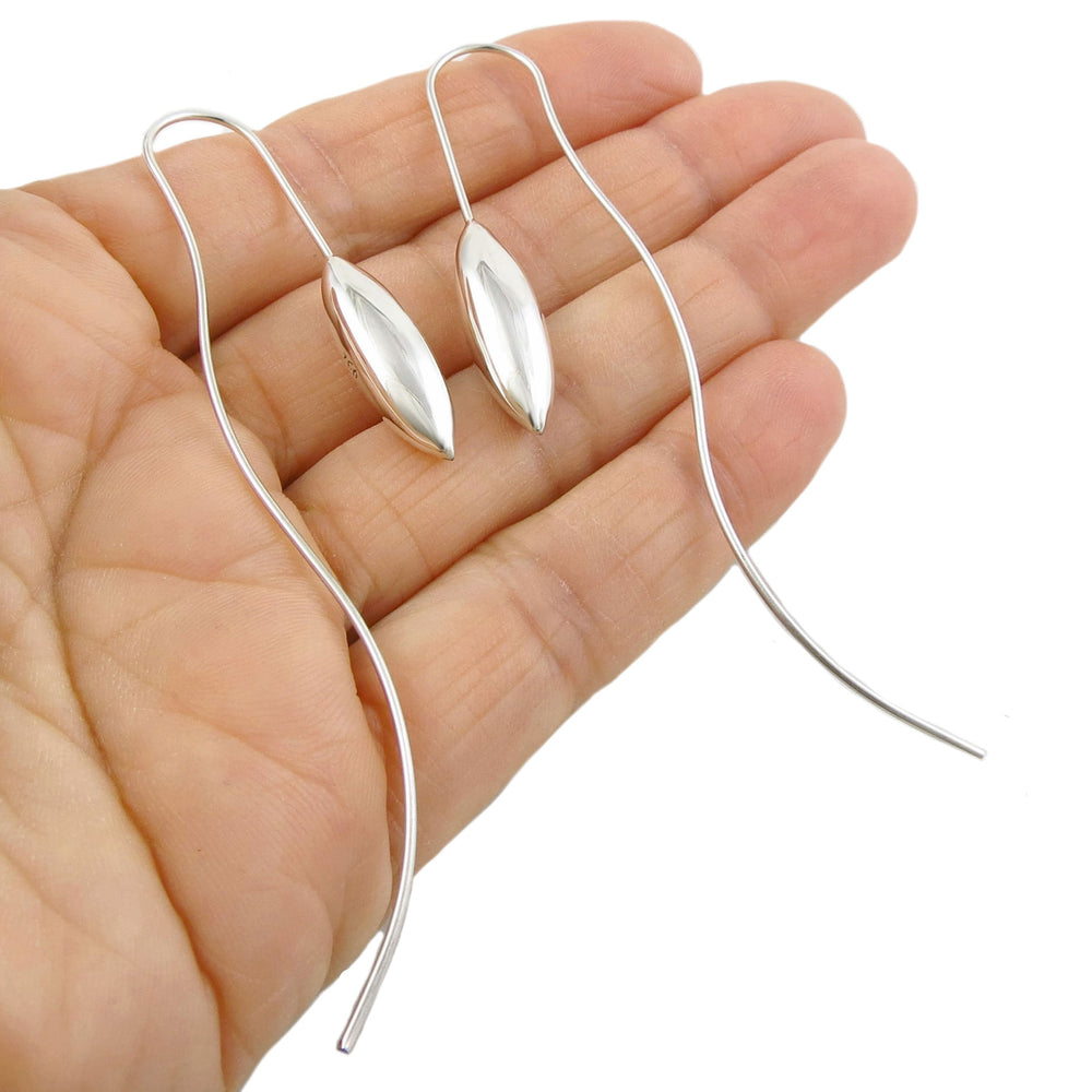 Long ssilver earrings with long threader hooks held in a person's hand