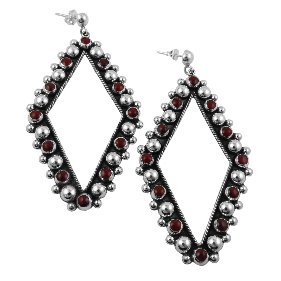Diamond-shaped hoop earrings with red stones on a white background