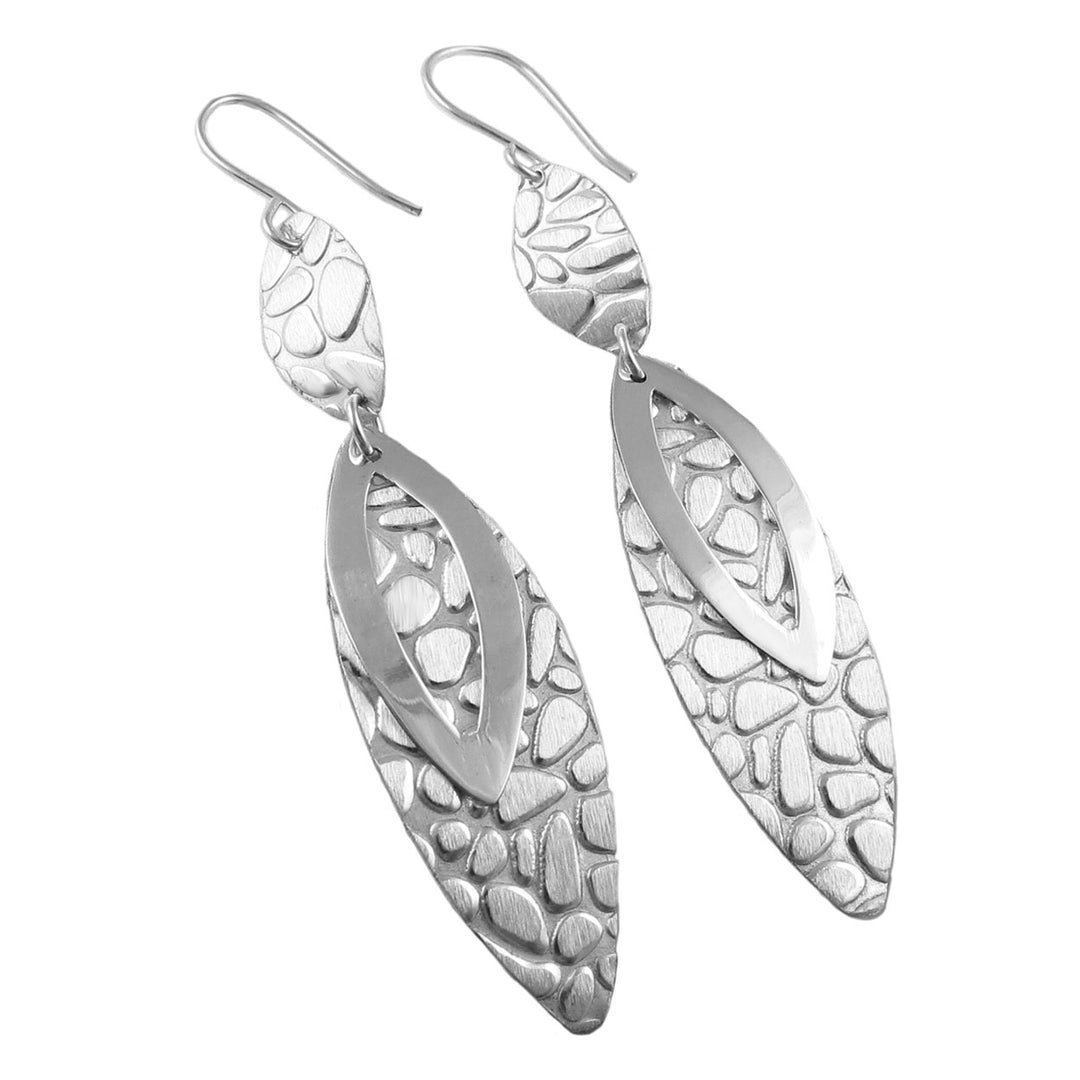 A pair of silver drop earrings with a brushed texture and polished finish, in an asymmetric design.