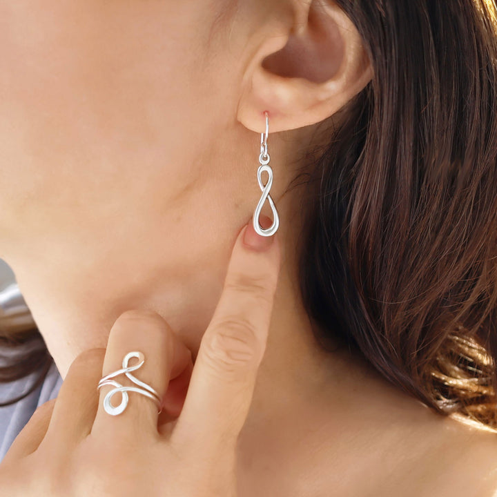 Sterling silver figure of eight drop earrings worn by a woman