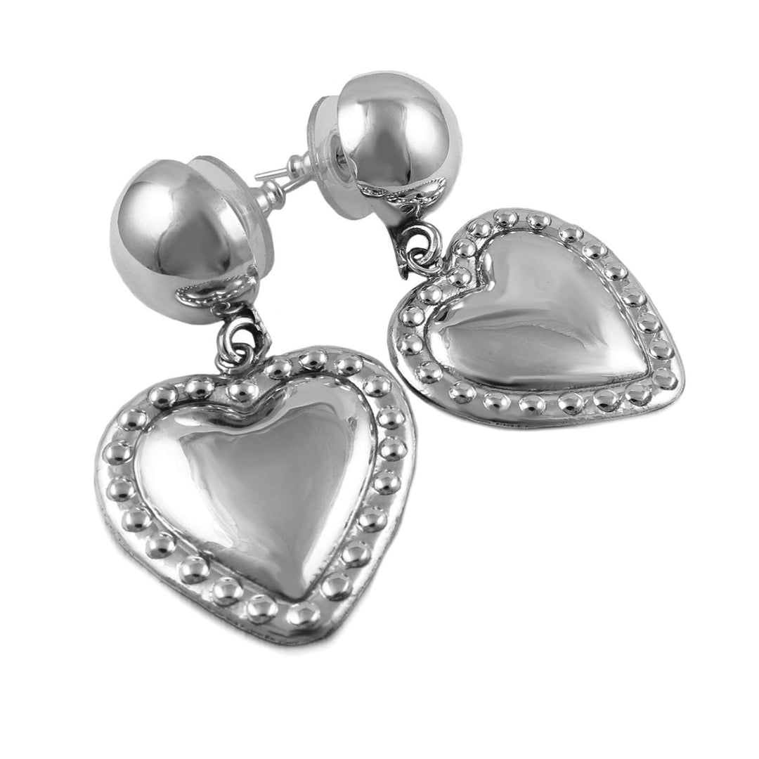 A pair of sterling silver heart-shaped earrings with a mirror-finish polish and bead detailing along the edges, hanging from large demi-beads on long posts.