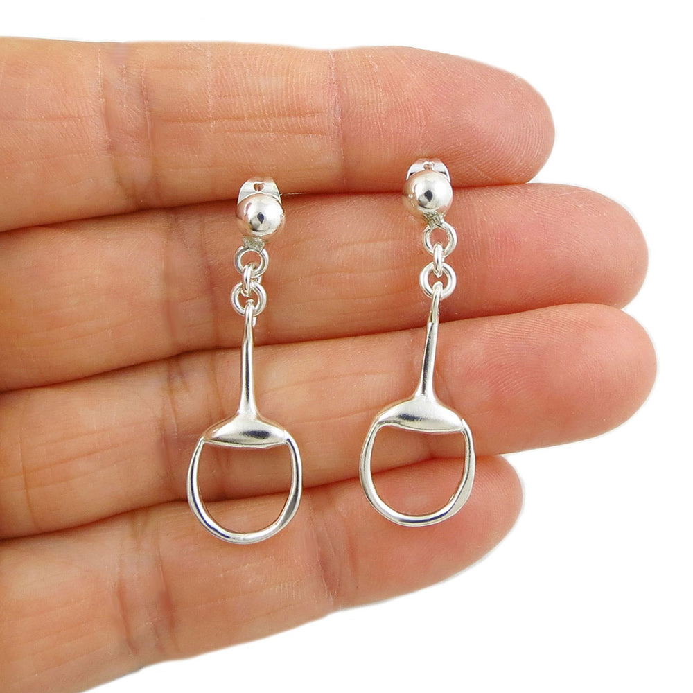 Horsebit snaffle earrings in 925 silver held in a person's hand on a white background