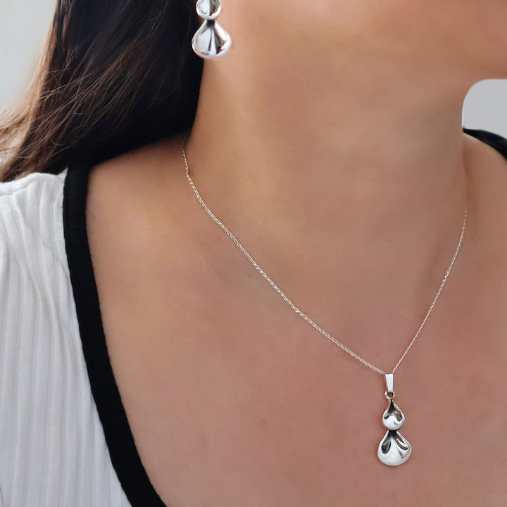 Silver necklace with a pendant worn by a person