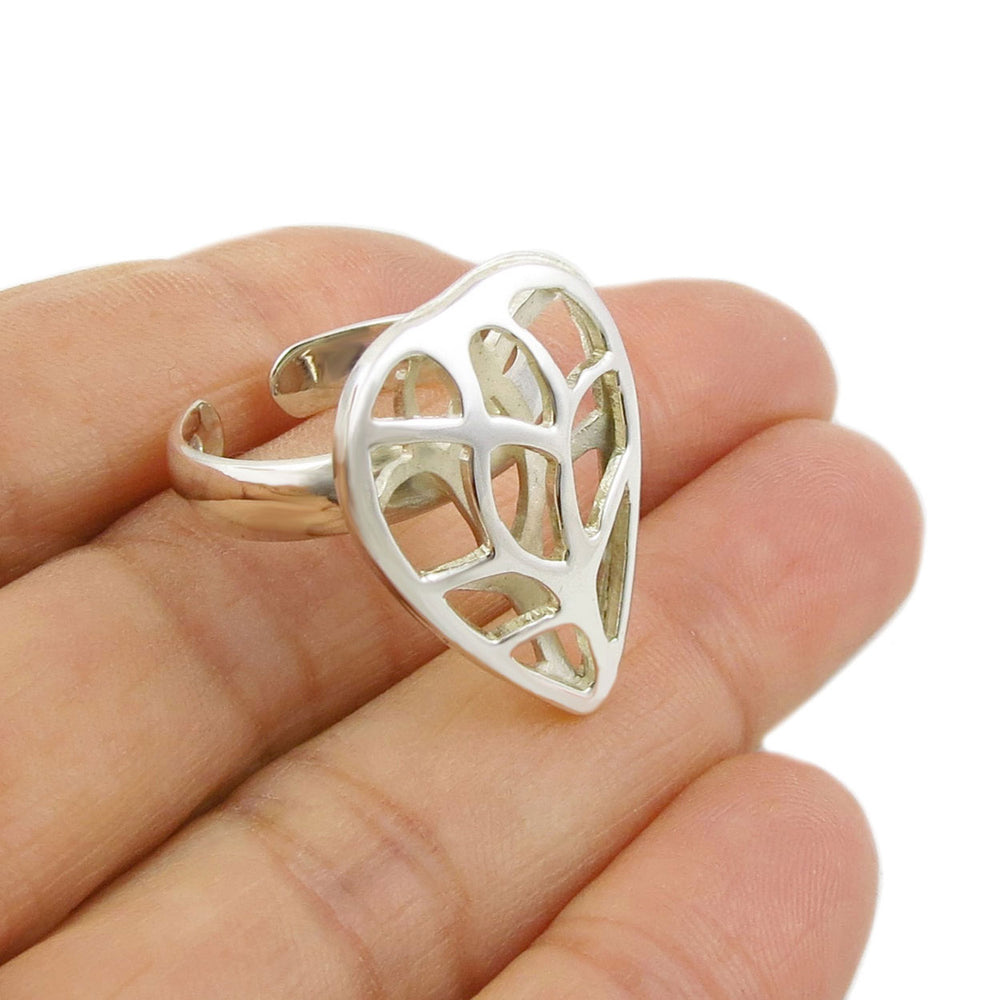 Silver leaf-shaped ring on a hand with a white background