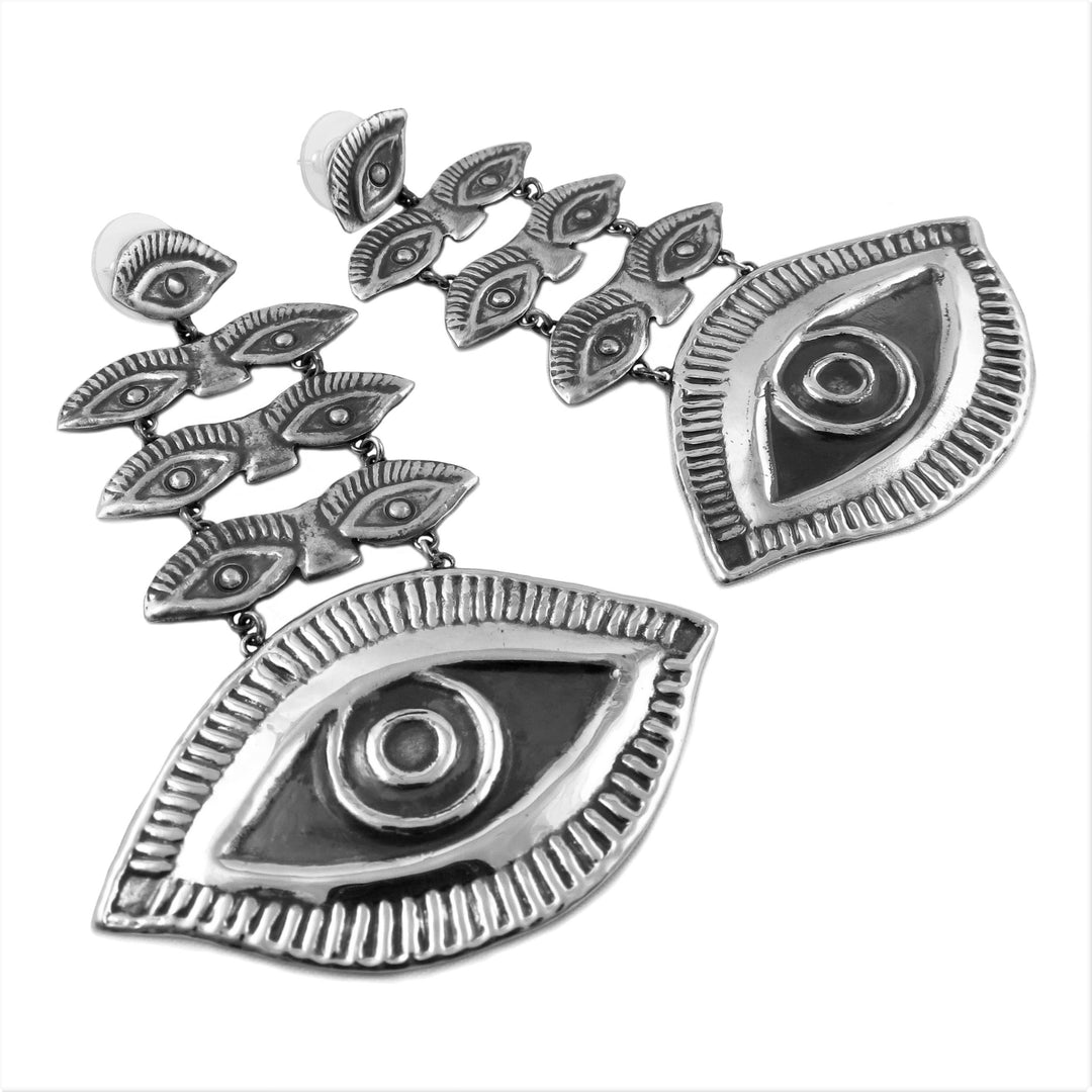 A pair of Maria Belen Nilson sterling silver evil eye earrings on a white background.