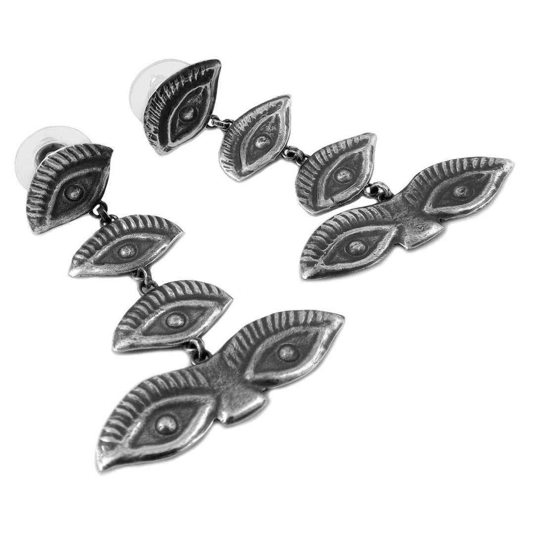 Silver evil eye earrings on a white background
