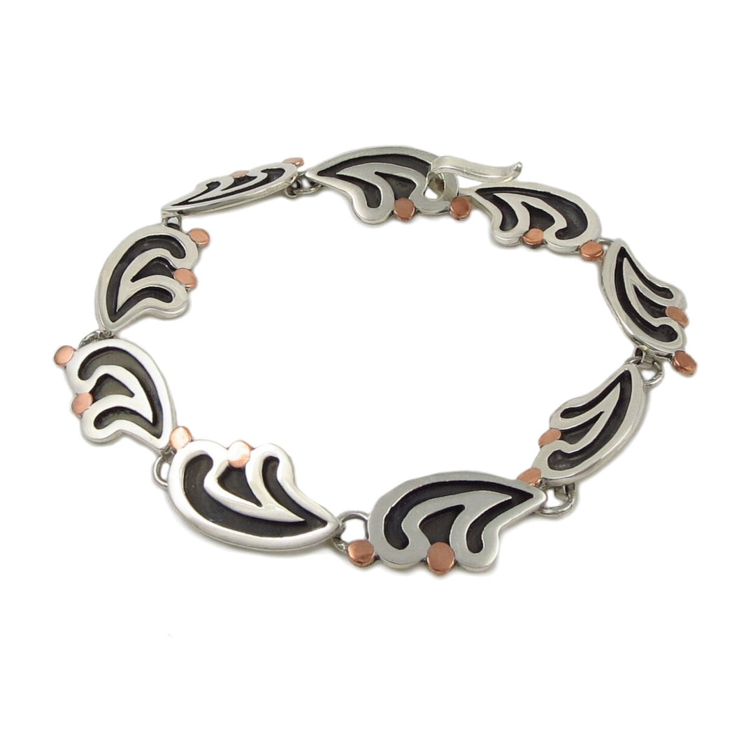 A two-tone silver bracelet with silver fern motifs accented with copper detailing, displayed against a white background.