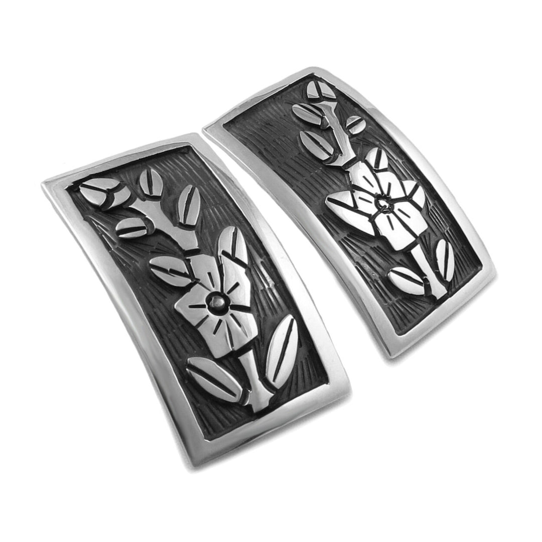 Maria Belen Nilson rectangle silver earrings with a flower pattern on a white background.
