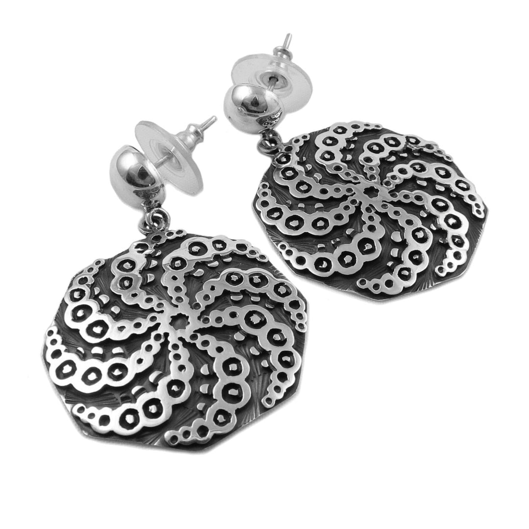 A pair of sterling silver earrings featuring a spiral design with a niello background.