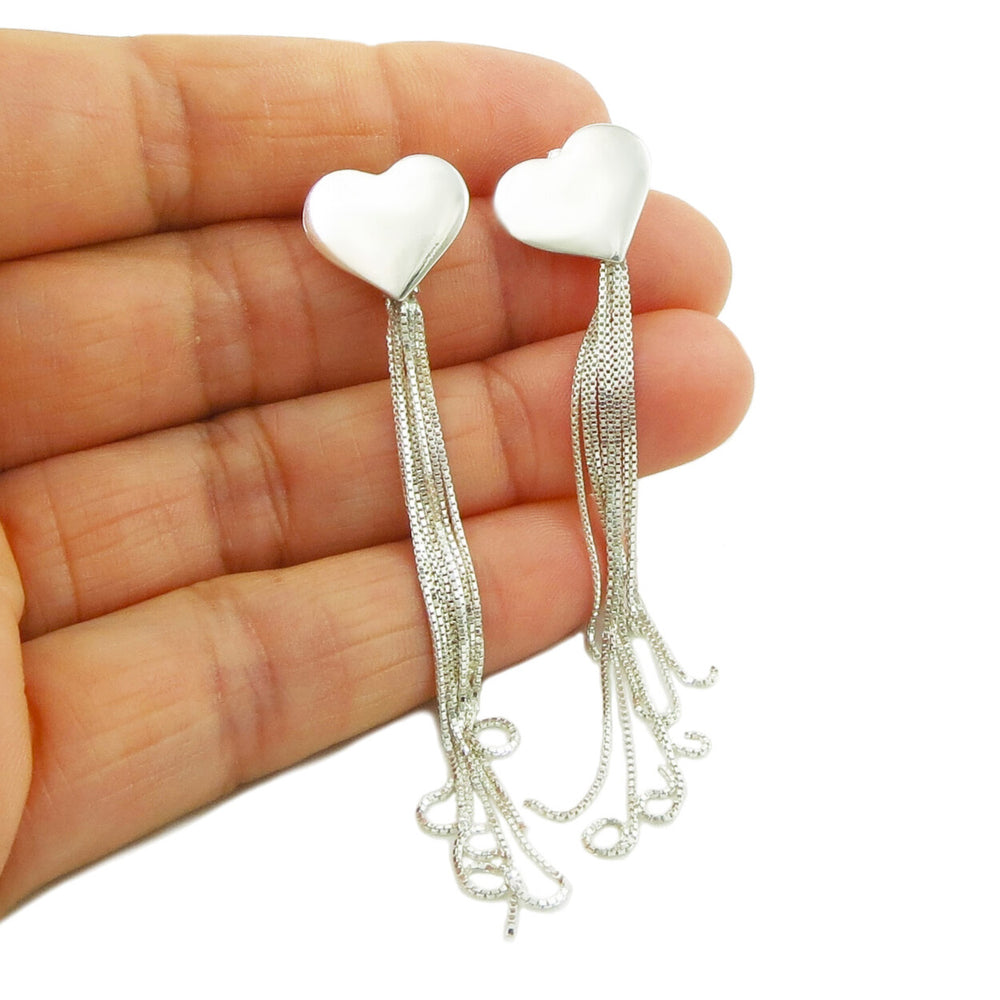 925 silver heart earrings with dangling chain fringes held in a person's hand.