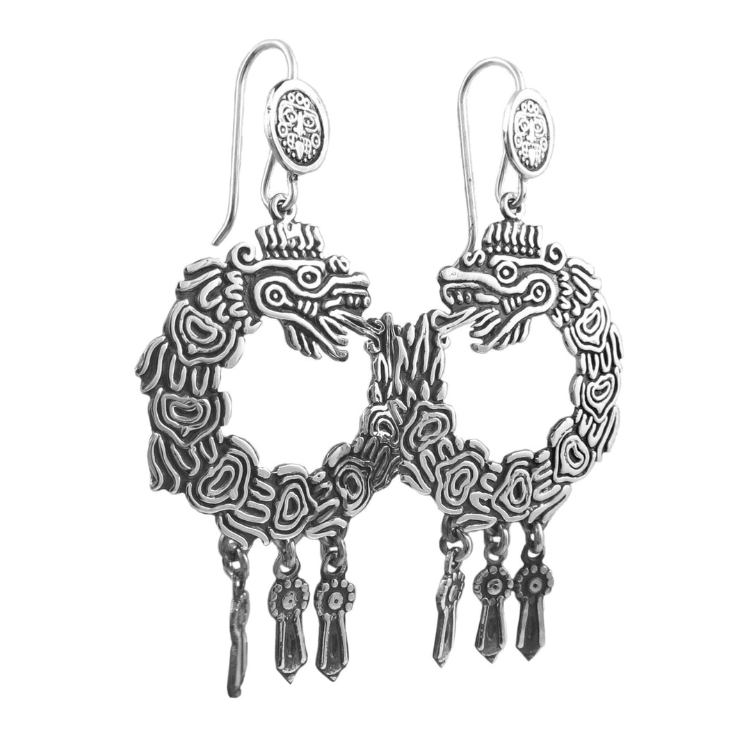 A pair of sterling silver dangle earrings with a circle of life design, featuring intricate patterns and drop fringe.