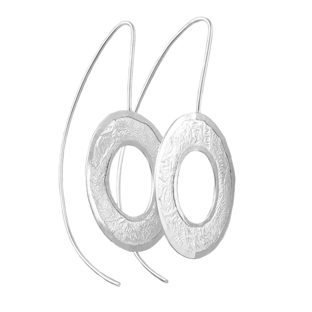Large Maria Belen Nilson sterling silver drop earrings with a crumpled paper finish on a white background.