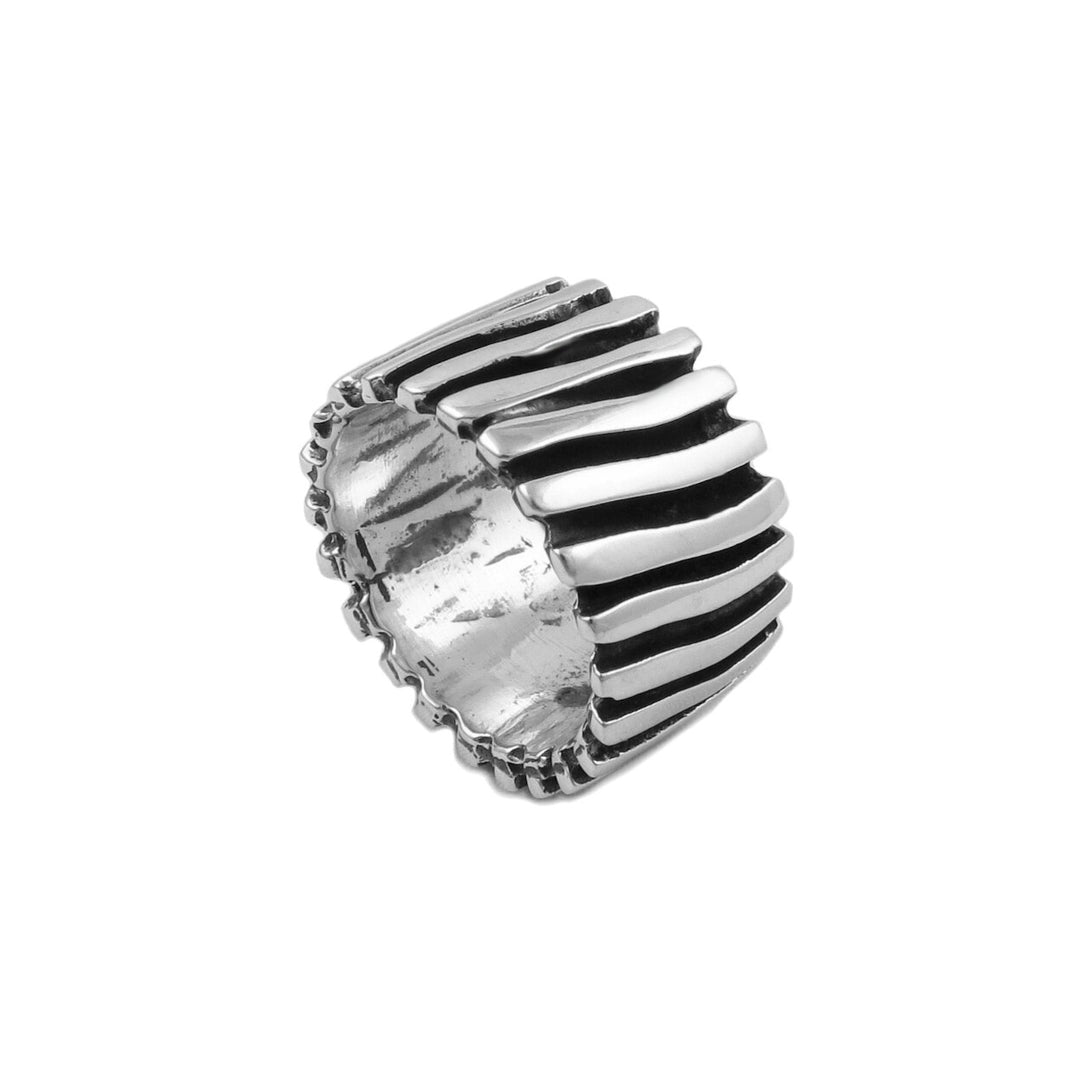 A wide chunky sterling silver ring with a modern grooved pattern on a white background.