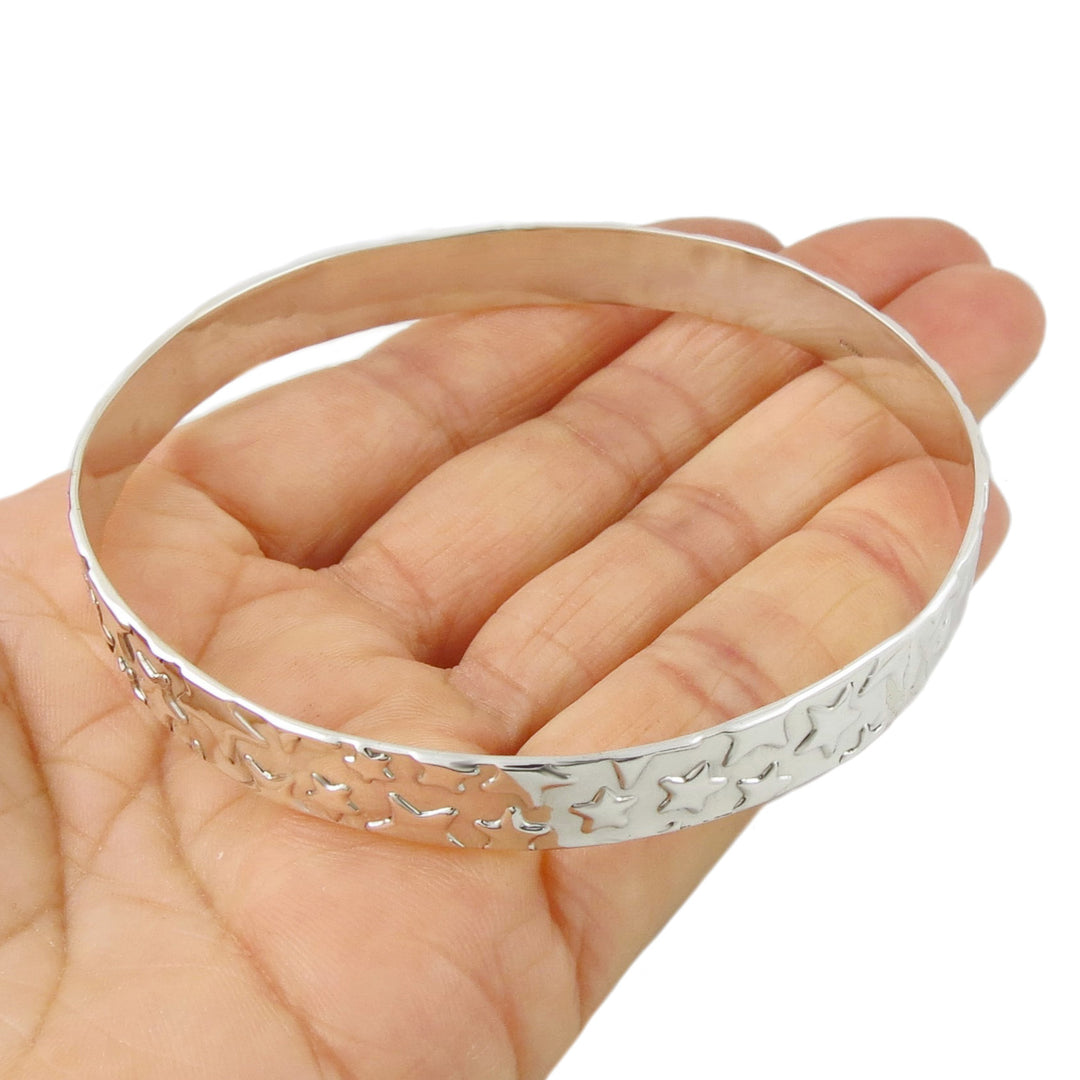 A silver circle bangle decorated with a raised star pattern. 