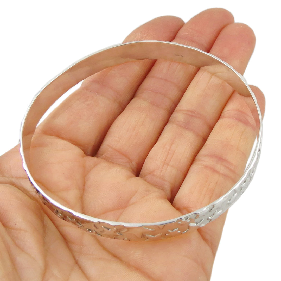 A large sterling silver bangle with a raised star pattern. 