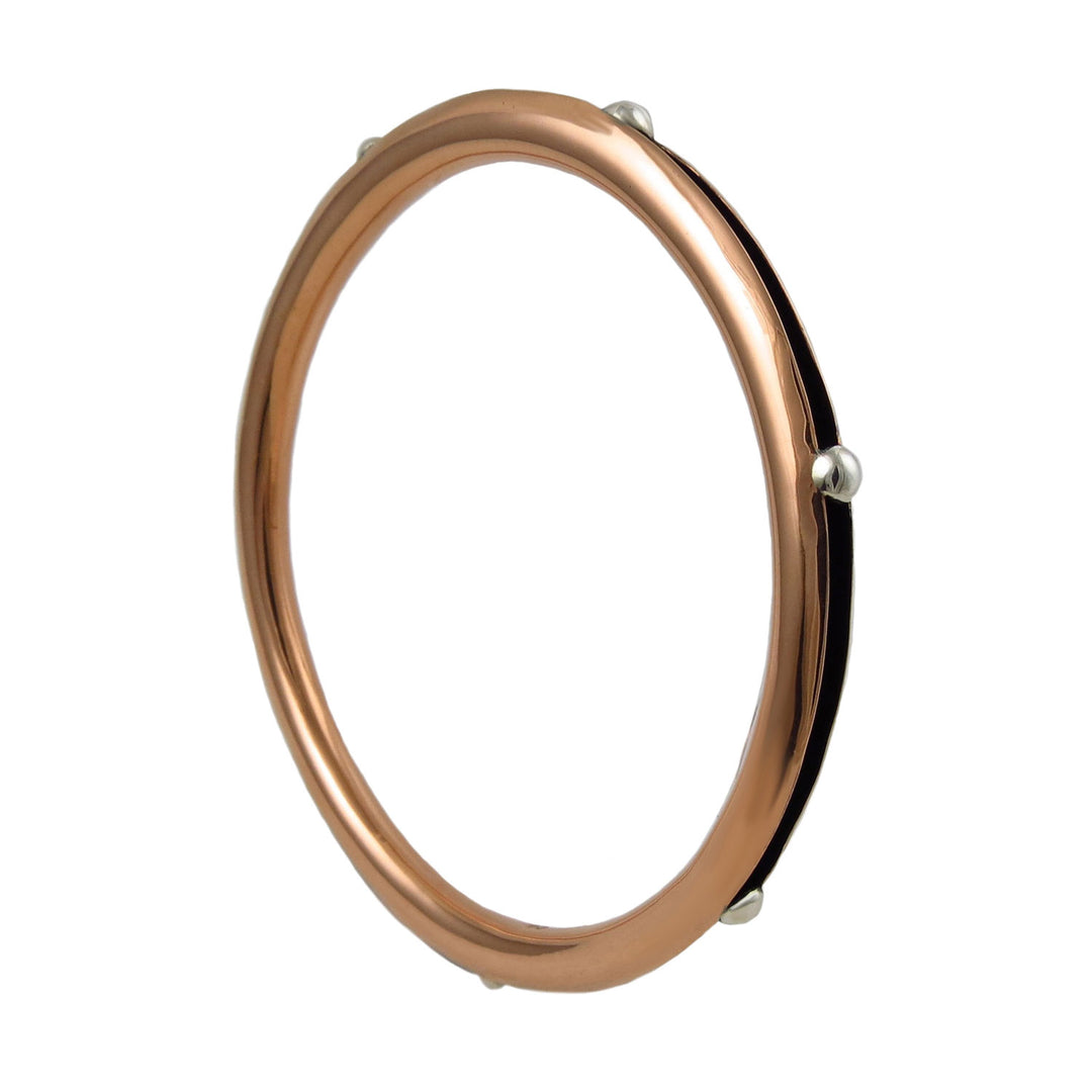 A large polished copper tube bangle for women with 925 silver accents on a white background. 