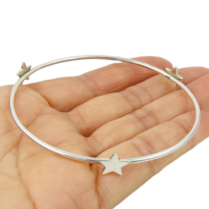 925 sterling silver bracelet bangle with stars held in a hand on a white background