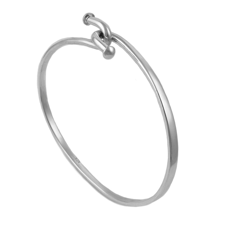 A large oval sterling 925 silver bangle bracelet with a twist hook fastening on a white background. 