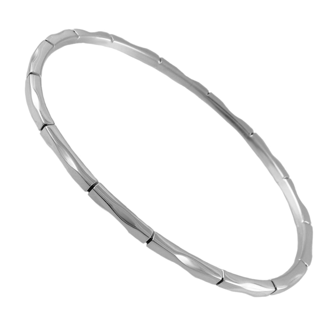 A large oval 925 sterling silver bangle with a UK halllmark and a unigue tapered edge in a bamboo pattern. 