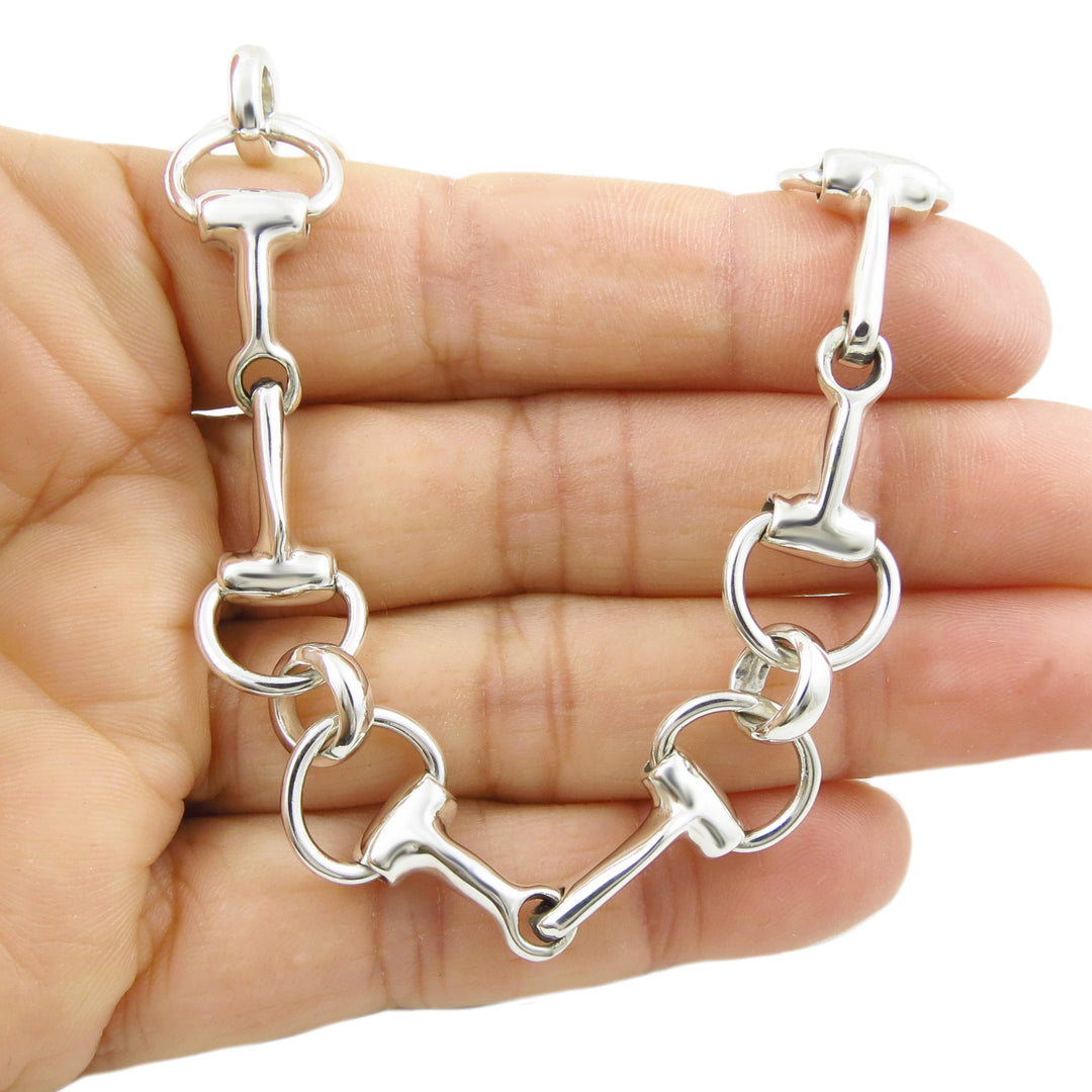 Sterling 925 silver bridle bit bracelet for women held in a hand against a white background