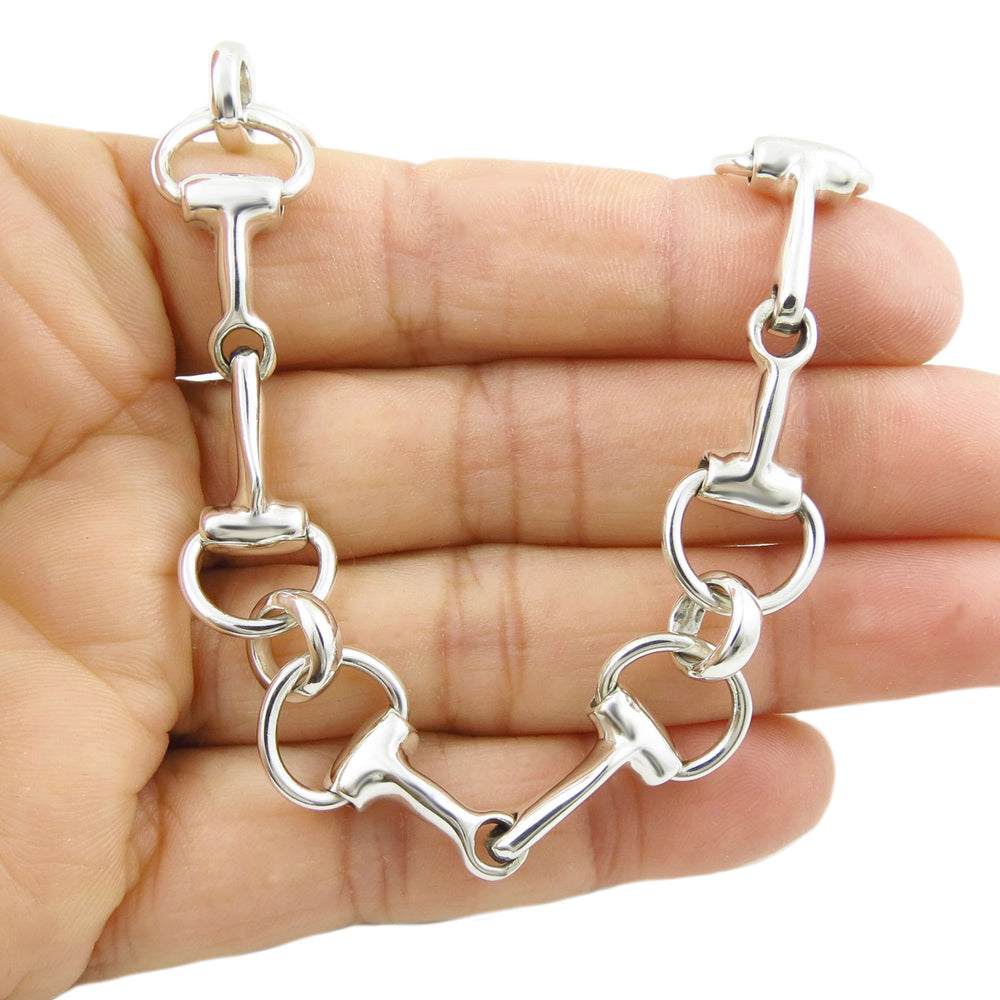 UK hallmarked sterling 925 silver horse bridle snafflebit bracelet for women held in a hand against a white background