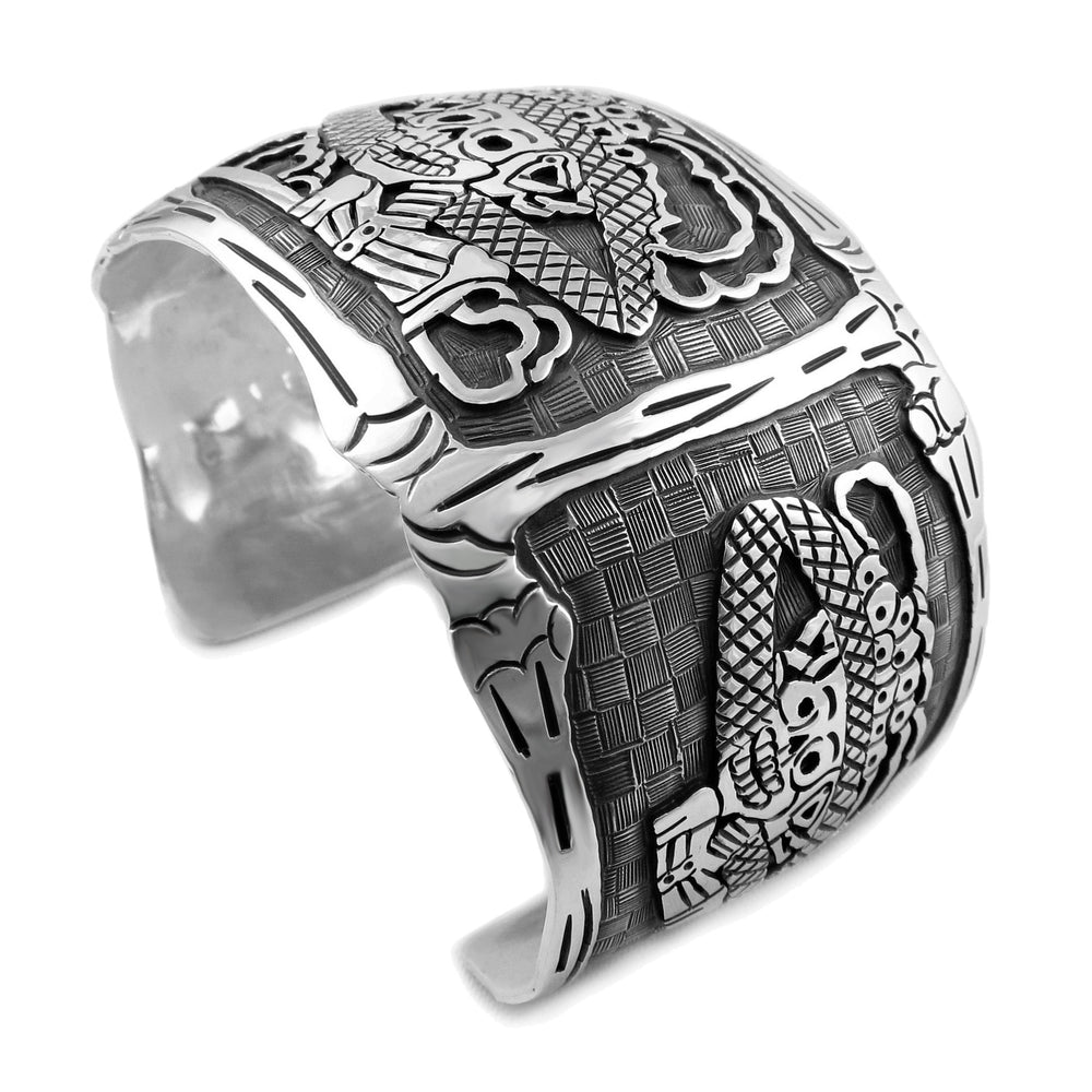 An intricate sterling silver bracelet cuff with etched blackened antiqued detail, showcasing a figure resembling La Catrina, associated with the Mexican Day of the Dead.