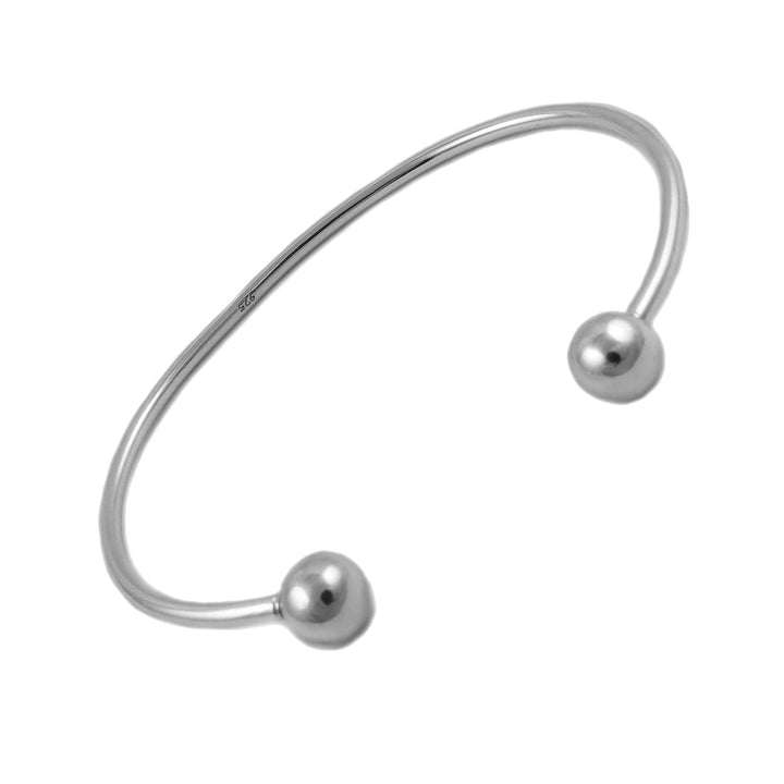 Silver bangle with two spherical beads on a white background