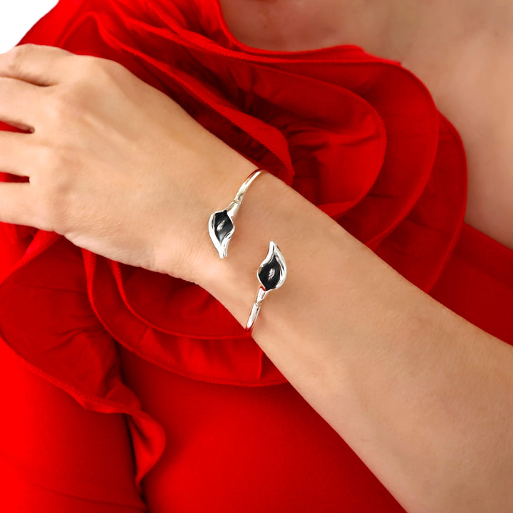 A woman in a red dress with a floral frill wearing a sterling silver calla lily bracelet cuff. 