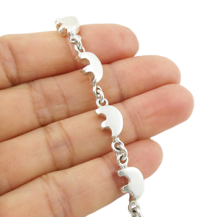 925 sterling silver bracelet with native american first nation bear totem links held between fingers on a white background