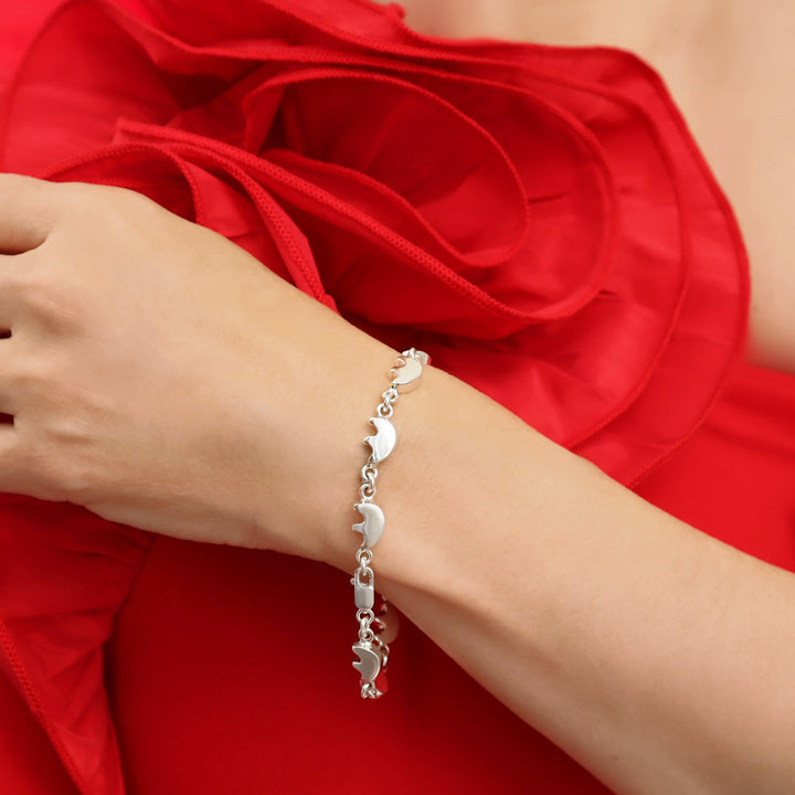 British sterling 925 silver bracelet with native american bear links on a woman's wrist against a red dress